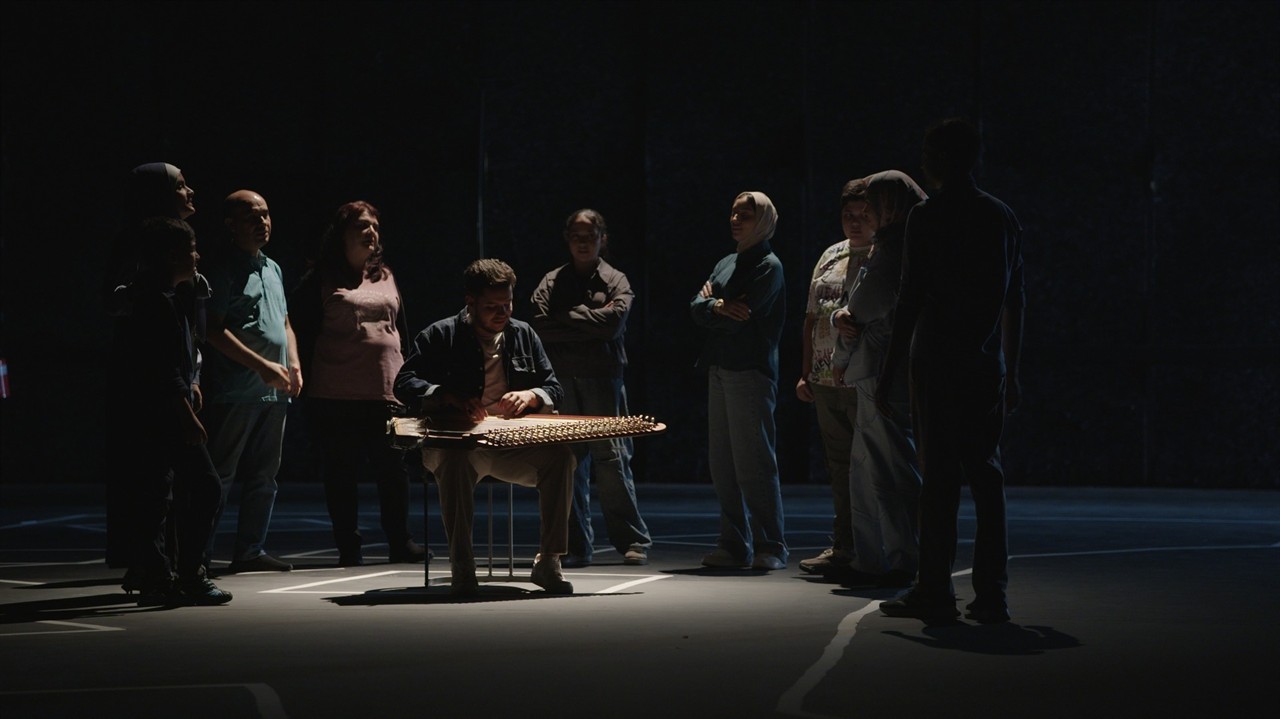 A group around a musician in a dark room